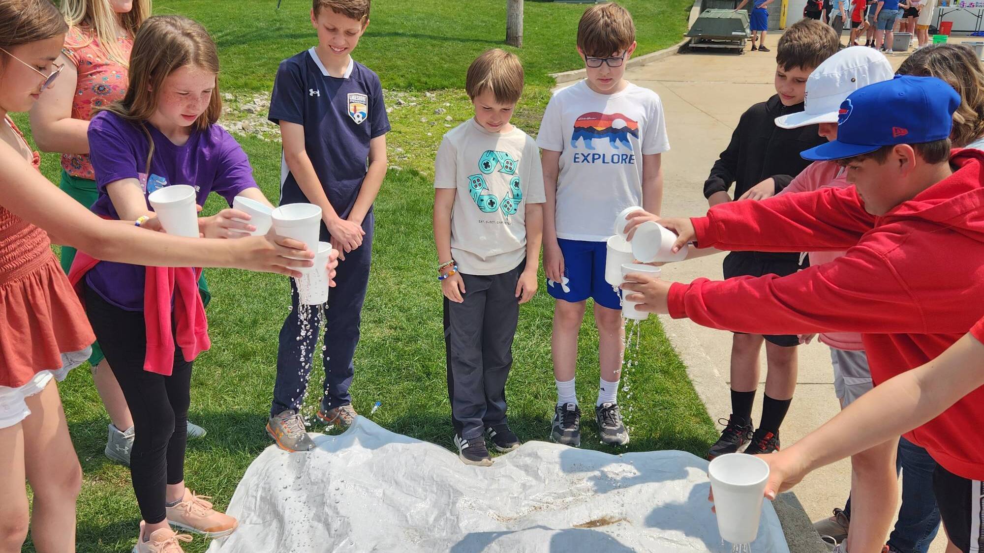 Students simulate a rainstorm over a model of a watershed during an AWRI landside program.